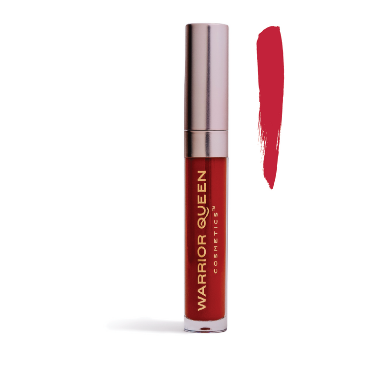 Fire red lip stain container labeled with gold Warrior Queen Cosmetics brand text and to the right of the container a vertical brush stroke of fire red color sample.